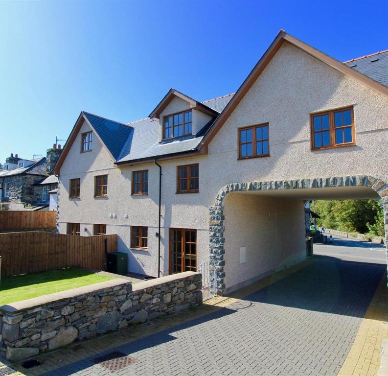 a large white house with a stone garage at Minafon in Llanbedr