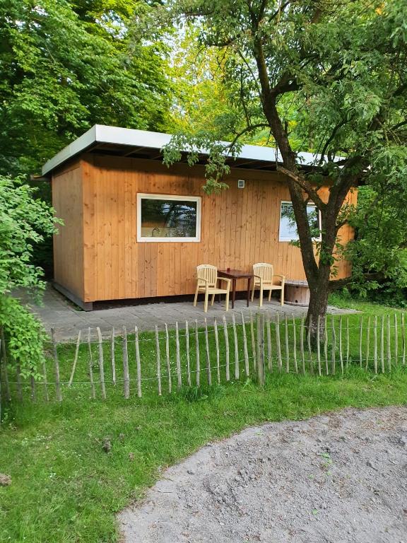 a small cabin with a table and chairs in a yard at Huisje de Bosrand in Bant