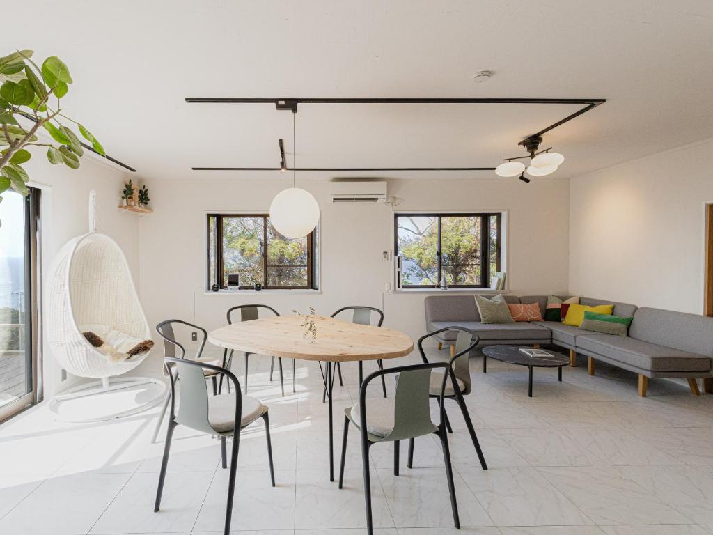 a living room with a table and chairs and a couch at The THERM in Munakata