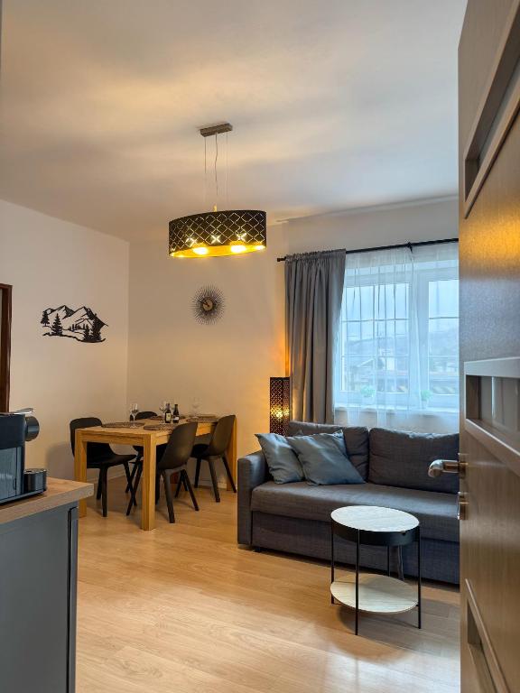 a living room with a couch and a table at Apartmán U Čápů Mladé Buky 59 in Mladé Buky