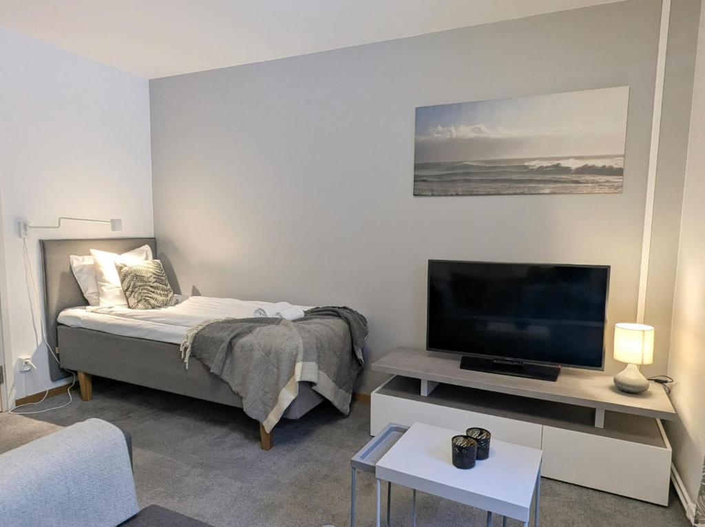 a bedroom with a bed and a flat screen tv at Forenom Hostel Gothenburg Säve in Gothenburg