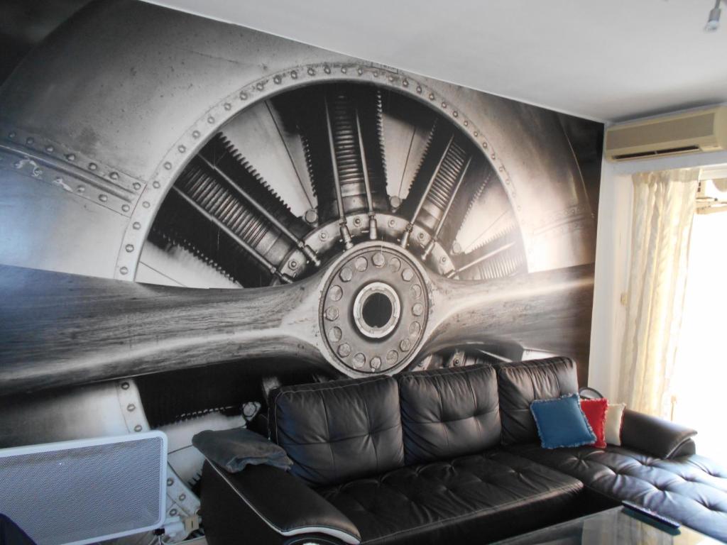 a ceiling in a room with a leather couch at Appartement Marco Polo in Mandelieu-La Napoule