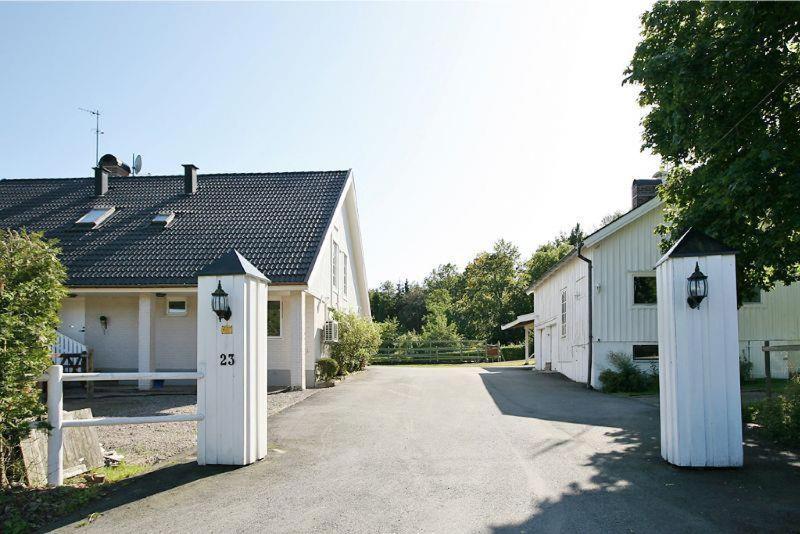 a house with two white gates in front of a driveway at Studio Ranch Johanna in Kullavik