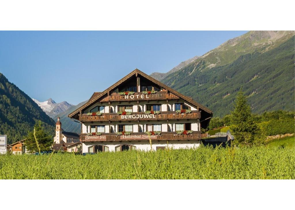a large wooden building in the middle of a field at B&B Hotel Bergjuwel in Neustift im Stubaital