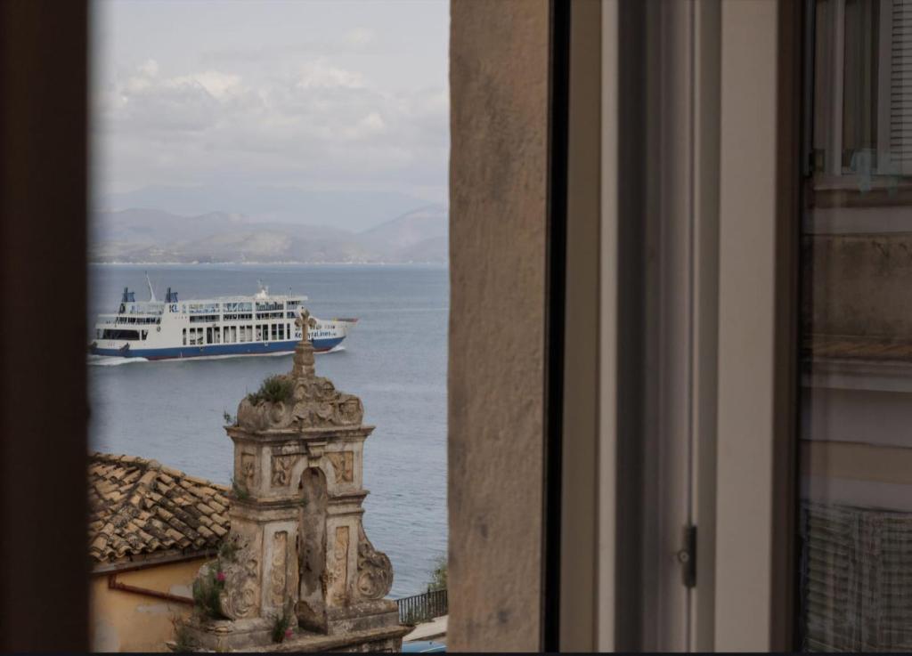a view of a boat in the water from a window at Mouragia by Kantoni in Corfu