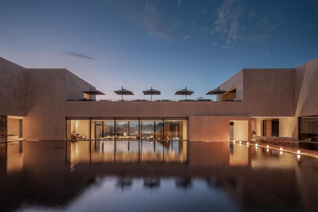 a building with a pool with umbrellas on top of it at PLAN B00b7ANADOL in Xianning