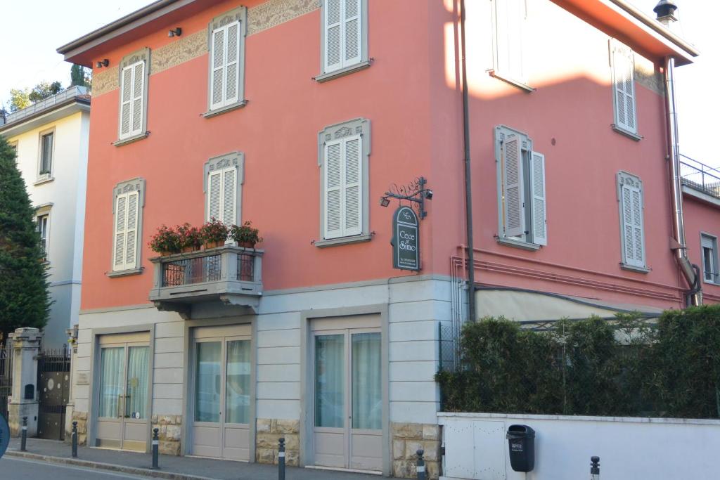 un edificio rosa con balcón en una calle en Locanda Cece e Simo, en Bérgamo