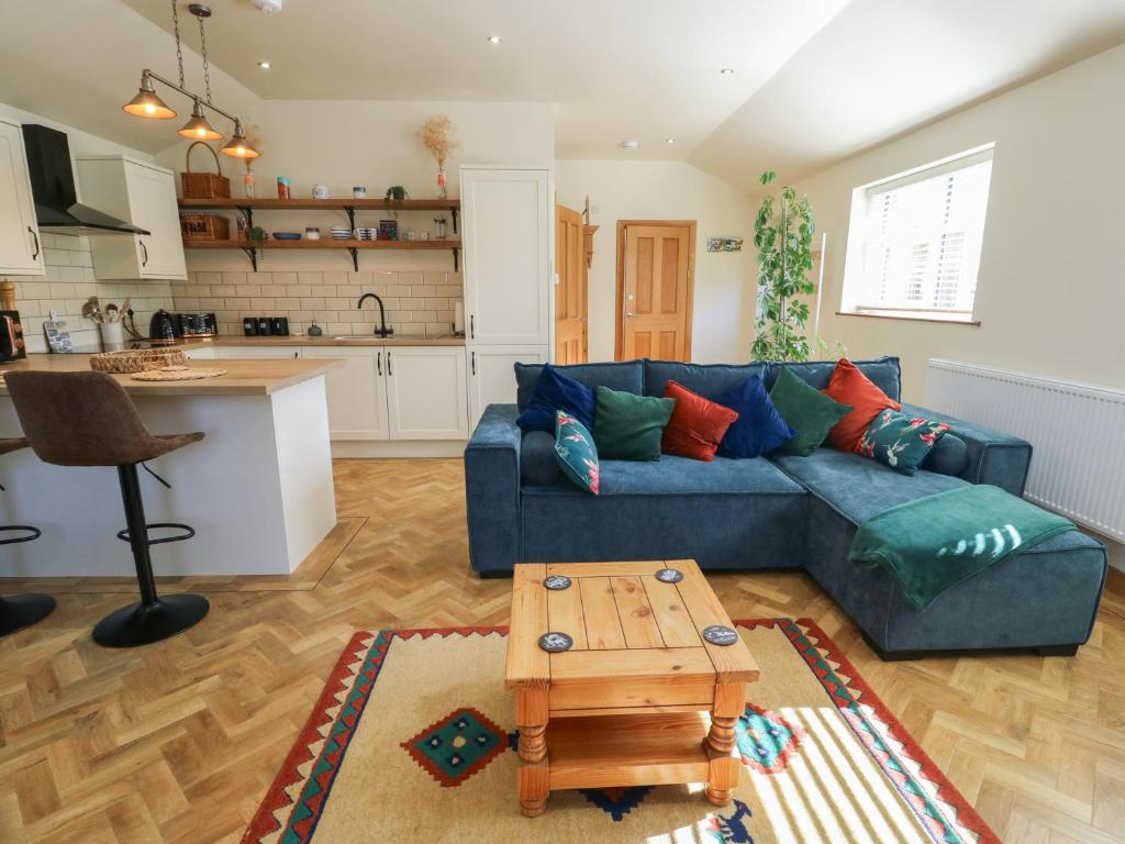a living room with a blue couch and a table at Trillo Lodge in Colwyn Bay