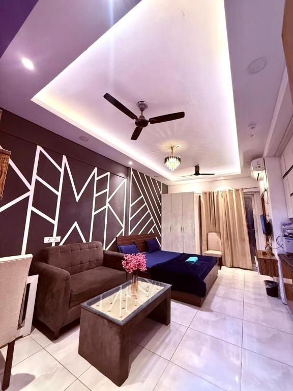 a living room with a couch and a ceiling fan at Luxe Haven Stays - Luxury Studio , Premium Stay in Noida