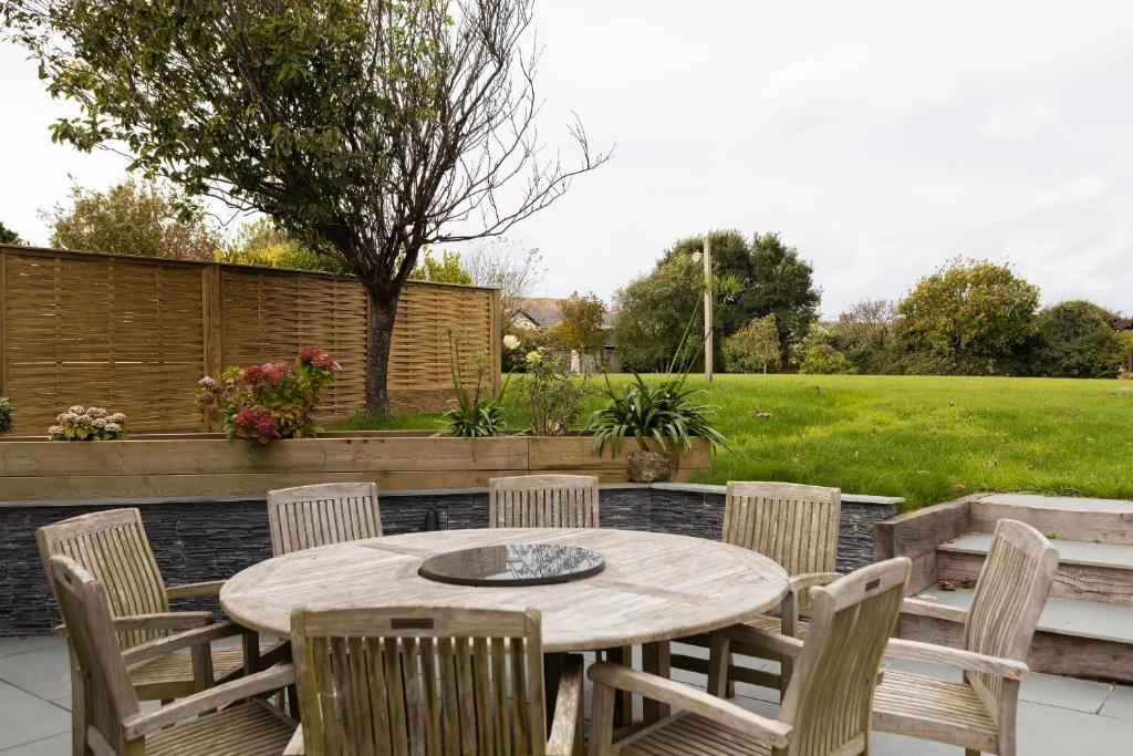 a patio with a table and chairs and a yard at Rose Cottage in Wadebridge