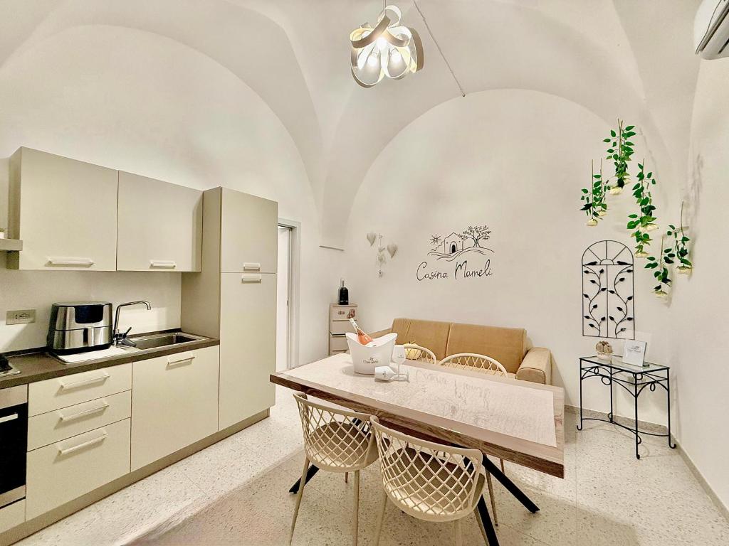 a kitchen with a table and chairs in a room at Casina Mameli in Nardò