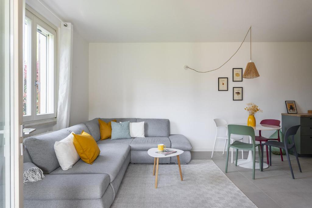 a living room with a gray couch and a table at MoKi by Garda FeWo in Moniga
