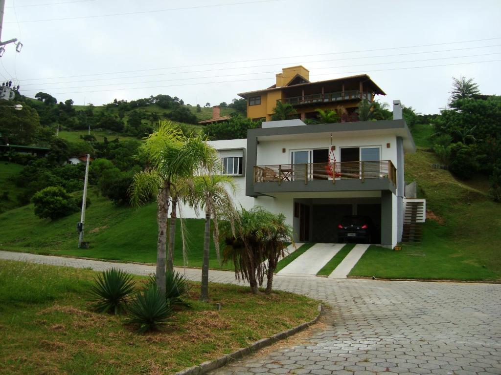a house on top of a hill with a driveway at Casa Morrinhos in Garopaba