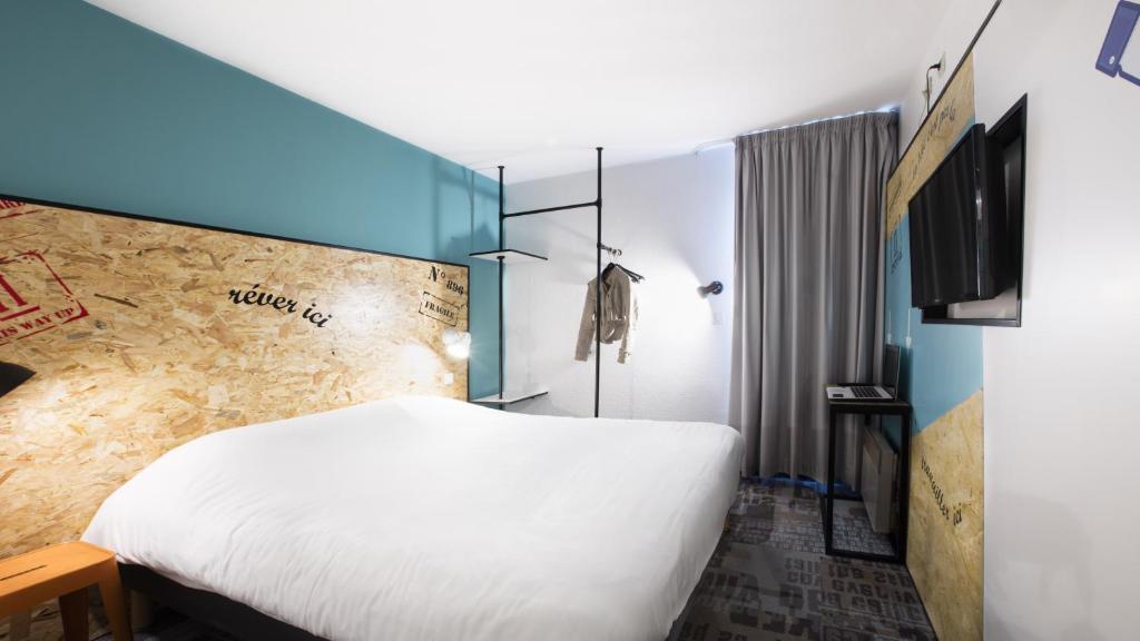 A bed or beds in a room at The Originals Access, Hôtel Clermont-Ferrand Nord