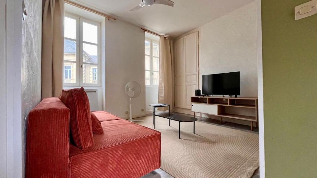 a living room with a red couch and a flat screen tv at Nevers à la Porte de Paris in Nevers