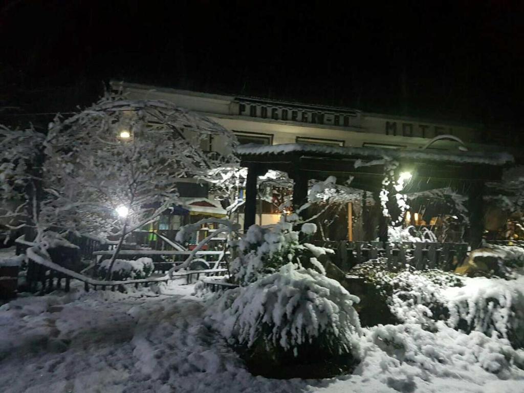 ein schneebedecktes Gebäude in der Nacht in der Unterkunft Podgorski An in Kolešino