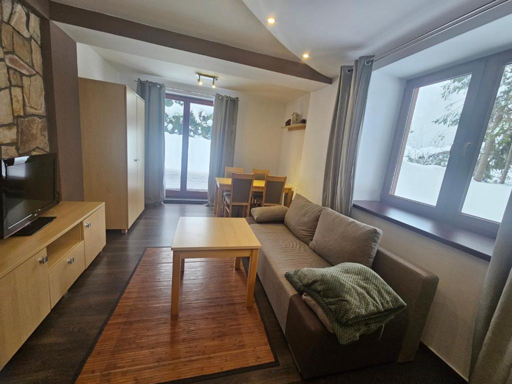 a living room with a couch and a table at Przystanek Dolina Kościeliska in Kościelisko