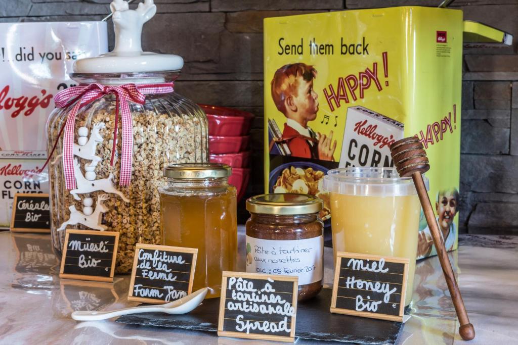 a table topped with jars of food and a drink at Les Monts Charvin in Courchevel