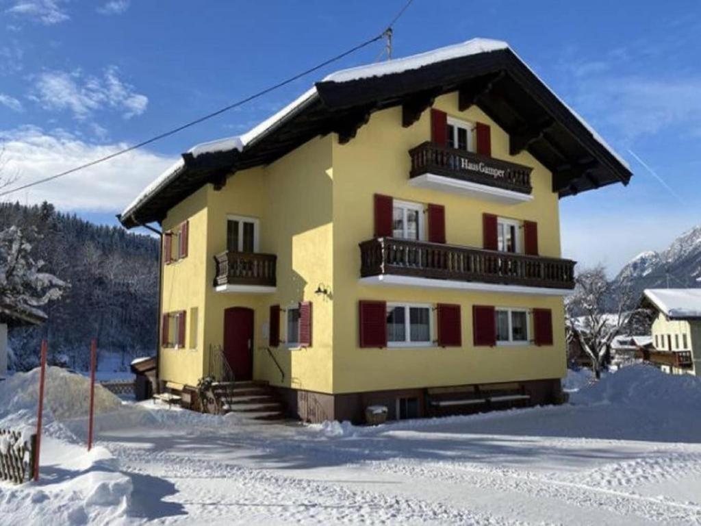 a building with snow on the ground in front of it at Chalet Gamper by Summit Travel in Ellmau