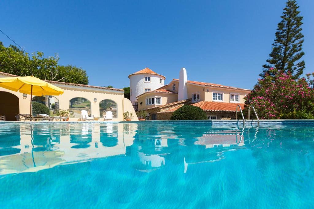 uma piscina em frente a uma casa em Quinta do Cabo Guesthouse em Sintra