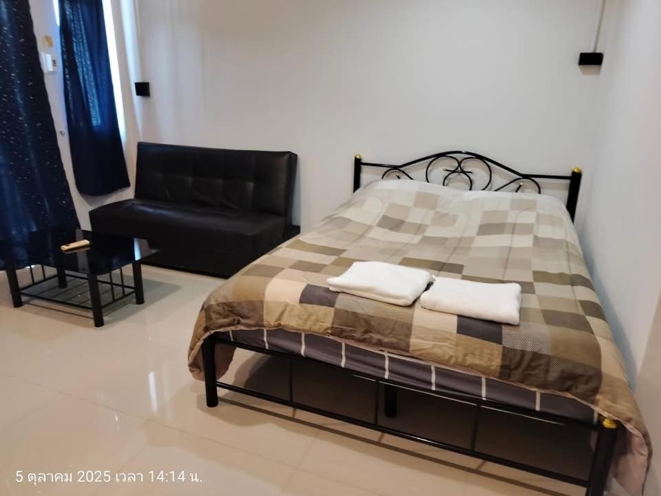 a bedroom with a bed and a couch and a chair at Pailin Daily F2 in Phetchabun