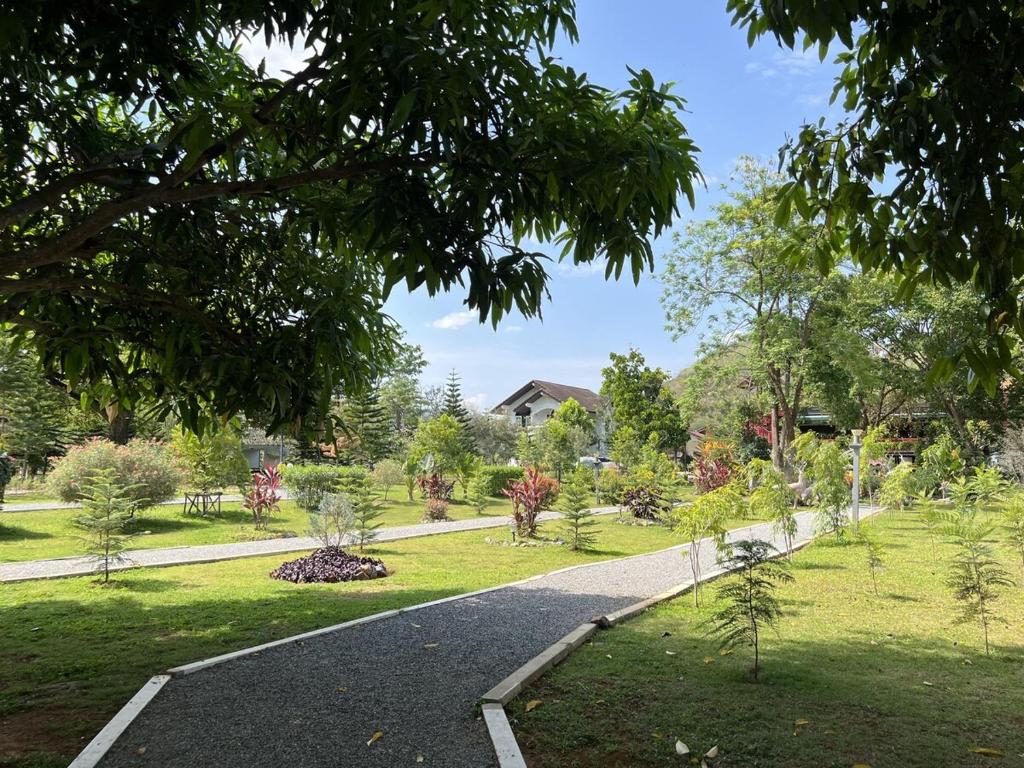 a path through a park with trees and plants at Bann Kieng Kiri Khaoyai บ้านเคียงคีรี เขาใหญ่ in Mu Si