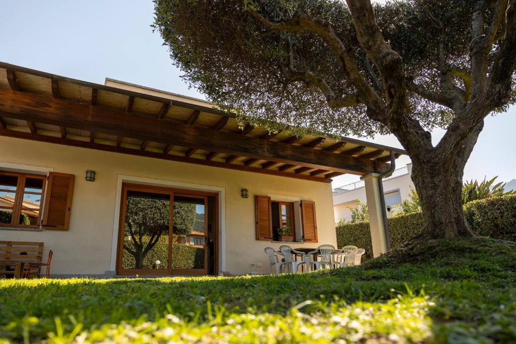 a house with a table and chairs under a tree at Villa Libo - HelloElba in Marciana Marina