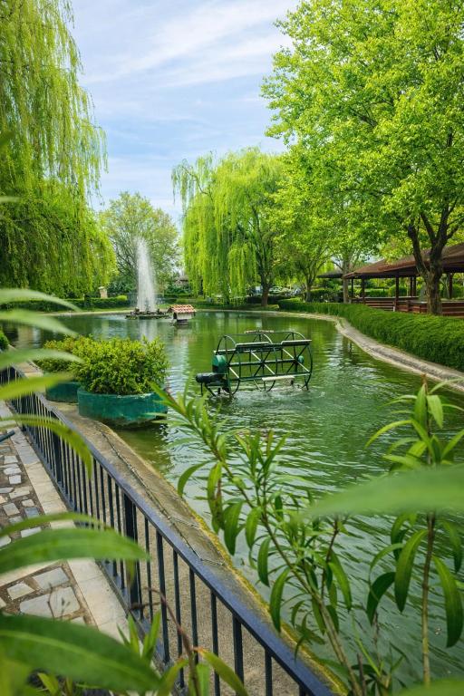 a pond in a park with a fountain in it at Hotel Bellevue in Skopje