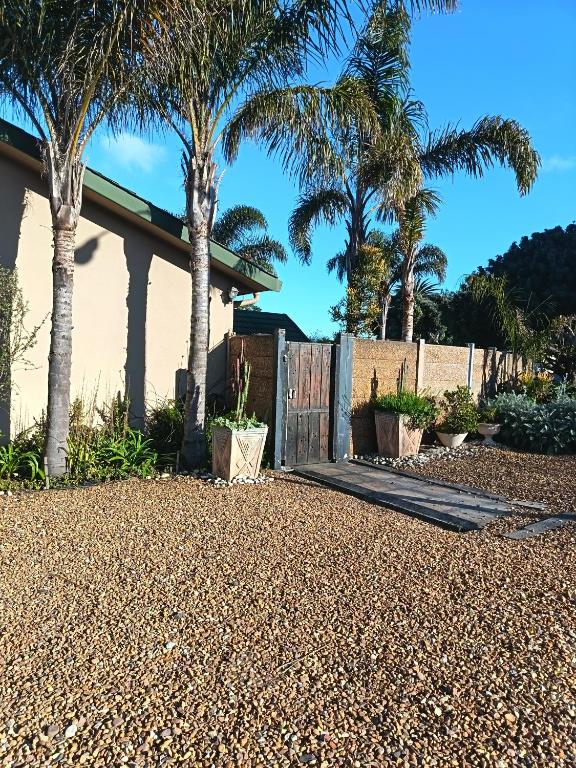 a fence with palm trees in front of a house at Danlavie in Tyger Valley