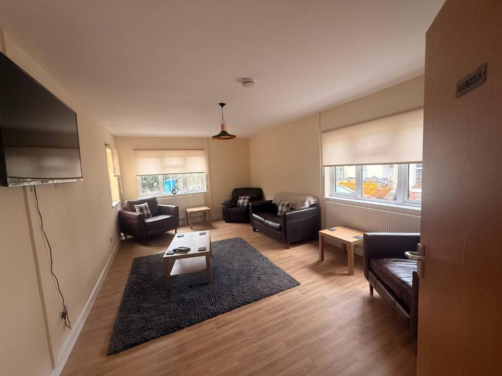 a living room with a couch and a table at Spacious House Sleeps 10 -Near BikePark Wales -Central -Parking in Troed-y-rhiw