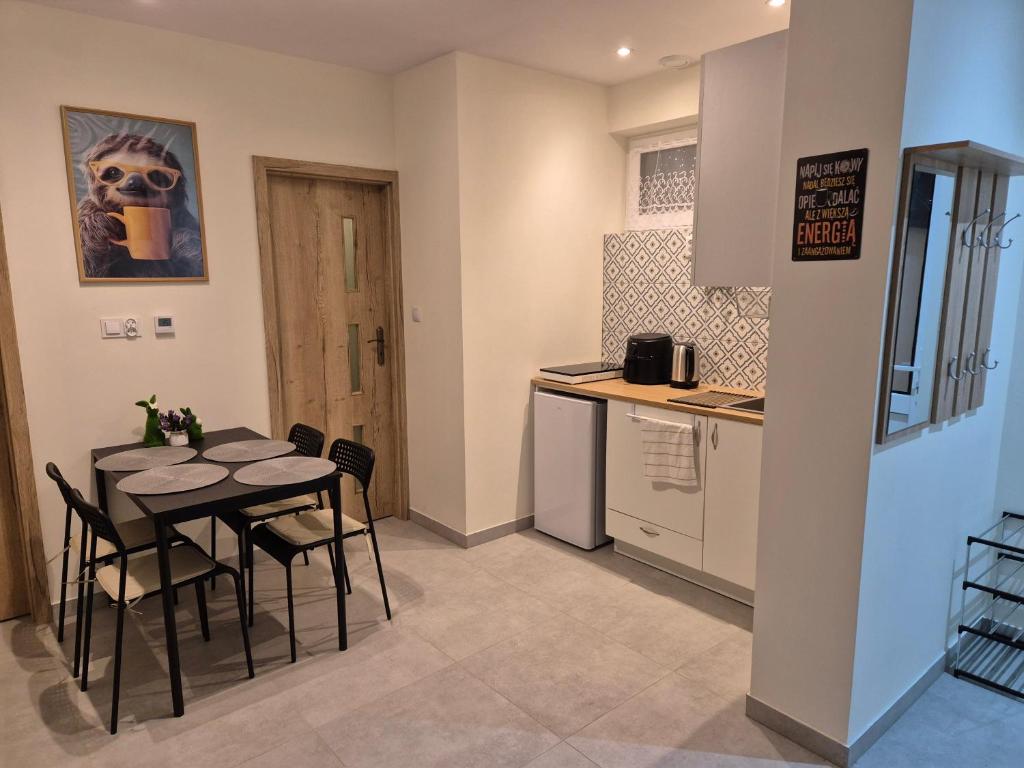 a kitchen with a table and chairs in a room at Apartament Pracowniczy in Mielec