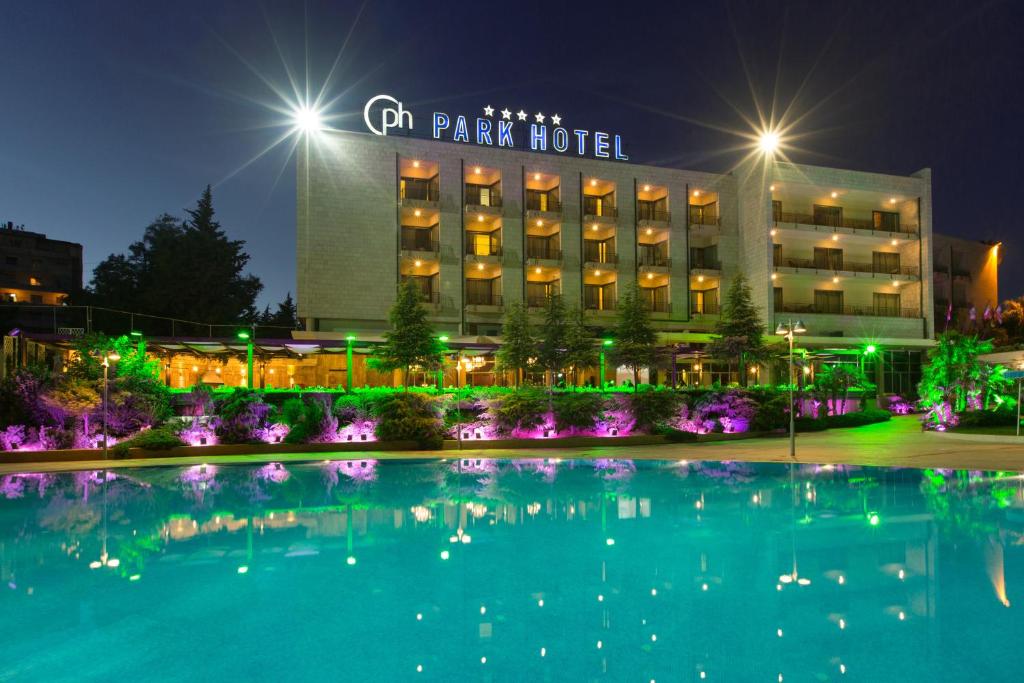 a hotel with a large swimming pool at night at Chtaura Park Hotel in Chtaura