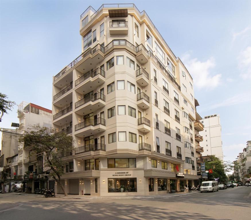 a tall white building on the corner of a street at Hong Ngoc Cochinchine Boutique Hotel & Spa in Hanoi