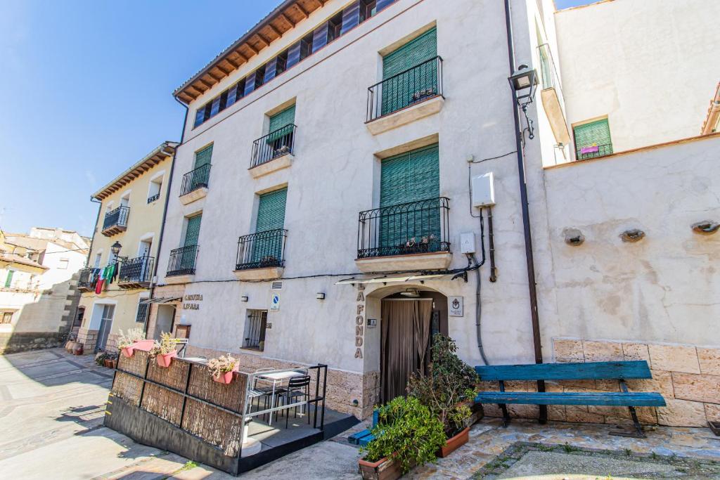 a building with a blue bench in front of it at Hostel El Castillo in Aniñon
