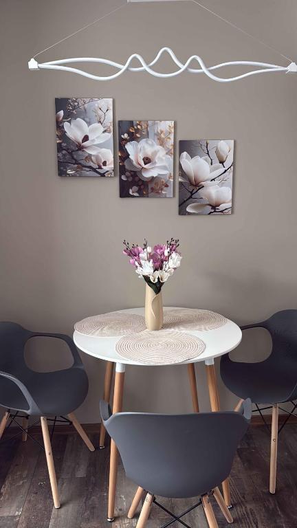 a table and chairs with a vase of flowers on it at Apartmány Rosijo in Lednice