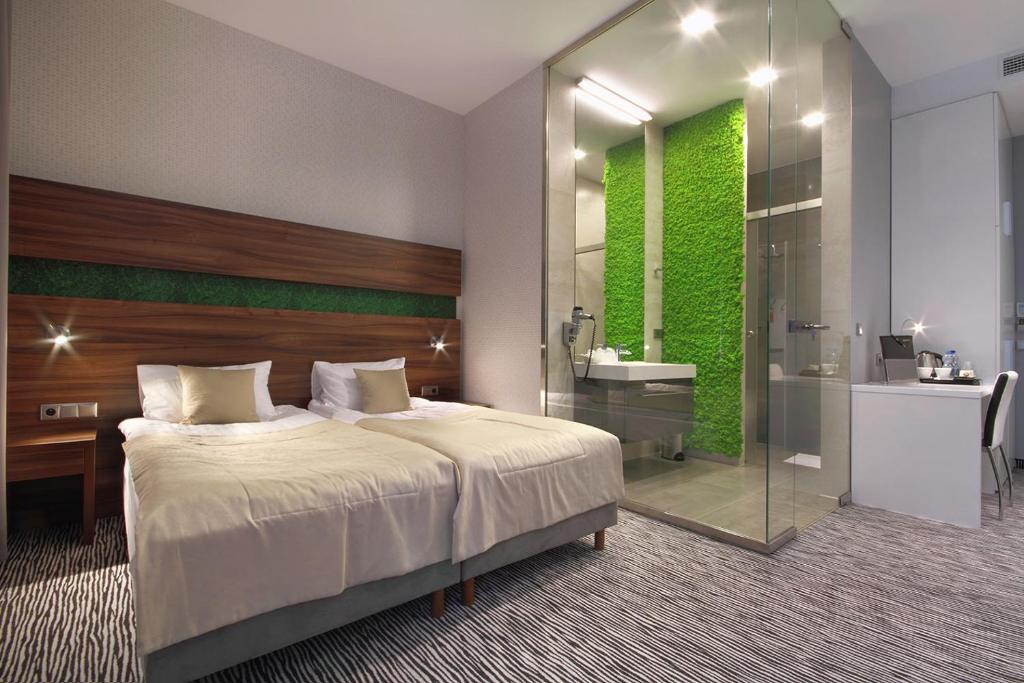 a bedroom with a bed and a bathroom with a shower at Hotel Gorczowski Katowice Chorzów in Chorzów