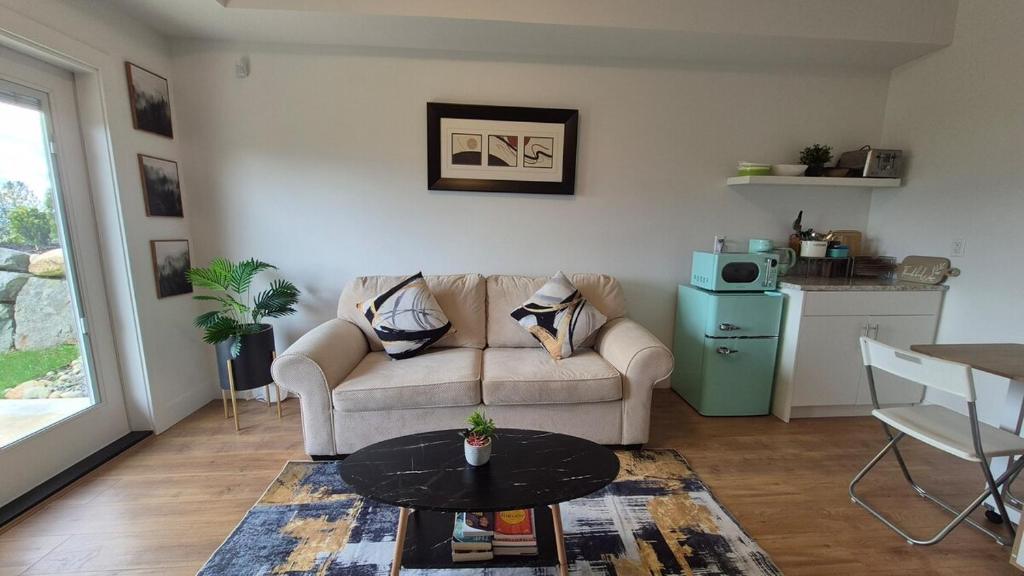a living room with a couch and a table at Elevated Horizon Retreat in Chilliwack