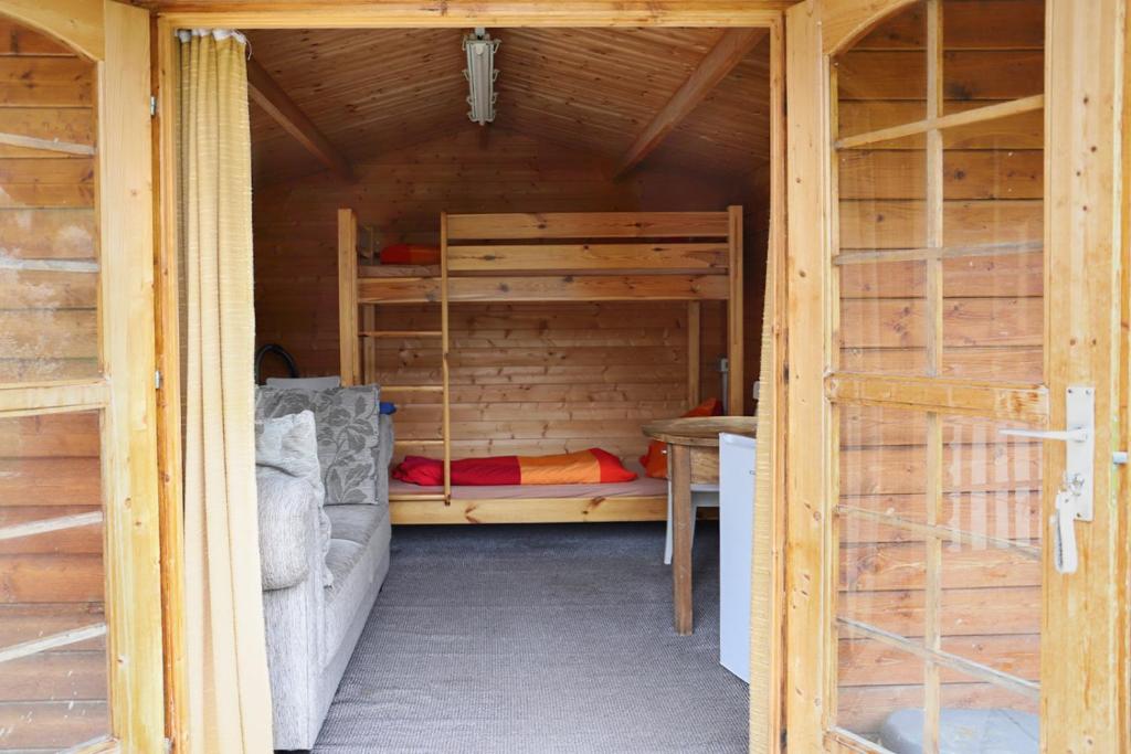 a room with two bunk beds in a wooden house at Nengshof Gartenhaus Wegerich in Wißmannsdorf