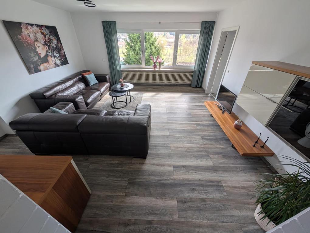 a living room with a couch and a television at Ferienwohnung Lux in Ortenberg