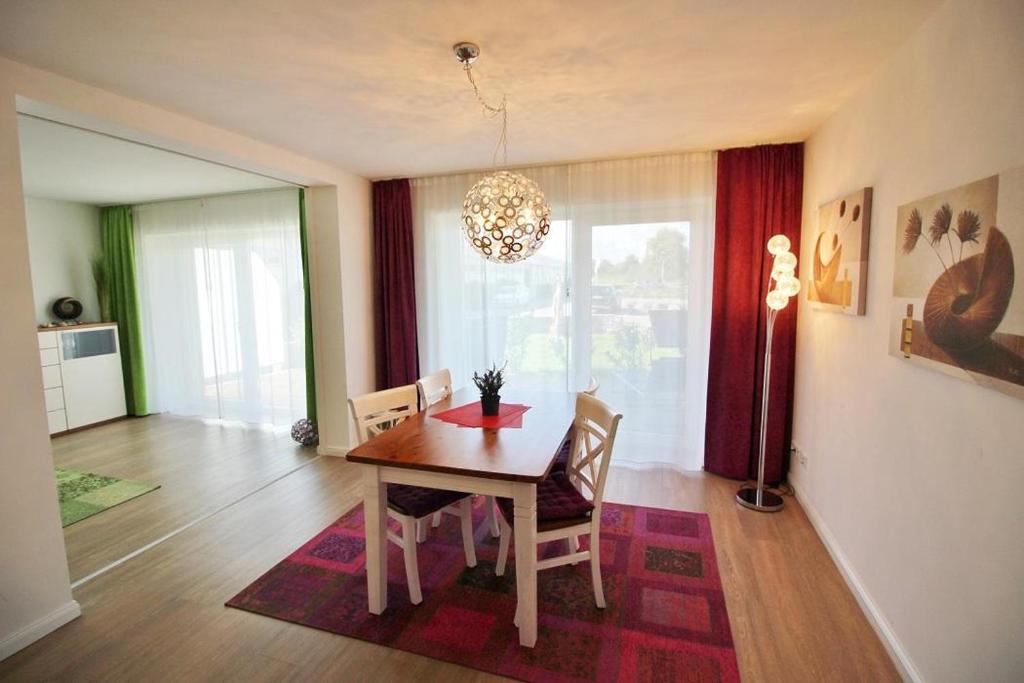 a dining room with a table and chairs and a chandelier at Golfresidenz D 0 06 in Grömitz