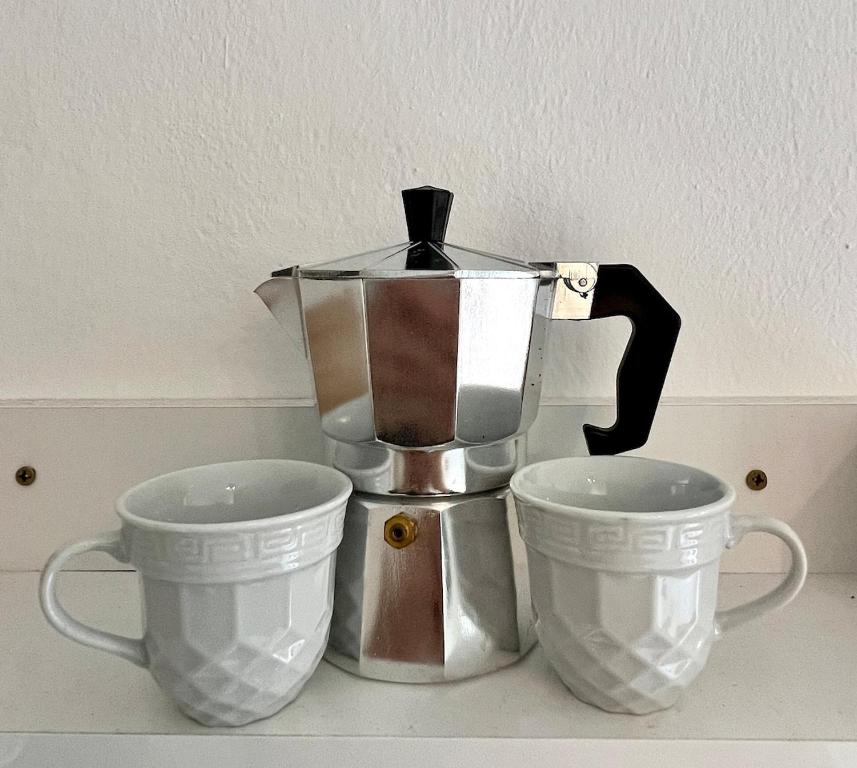 a coffee pot and two cups on a counter at Little apartment in Hammamet