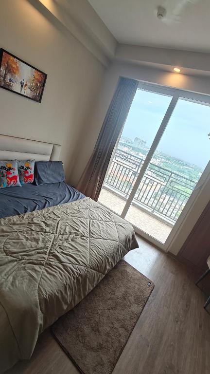 a bedroom with a bed and a large window at Romaer's Room in Greater Noida
