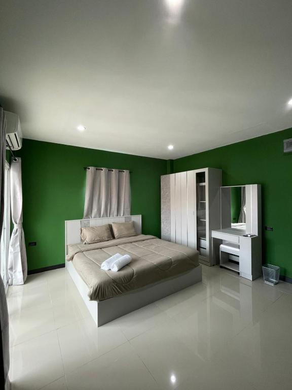 a bedroom with green walls and a large bed at The Smoke Shop in Ban Suan