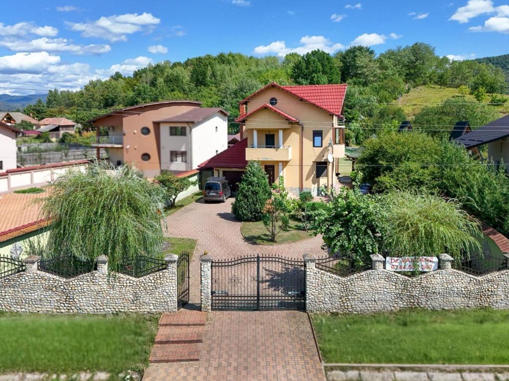 a house with a fence and a driveway at Casa RUXI in Jiblea Veche