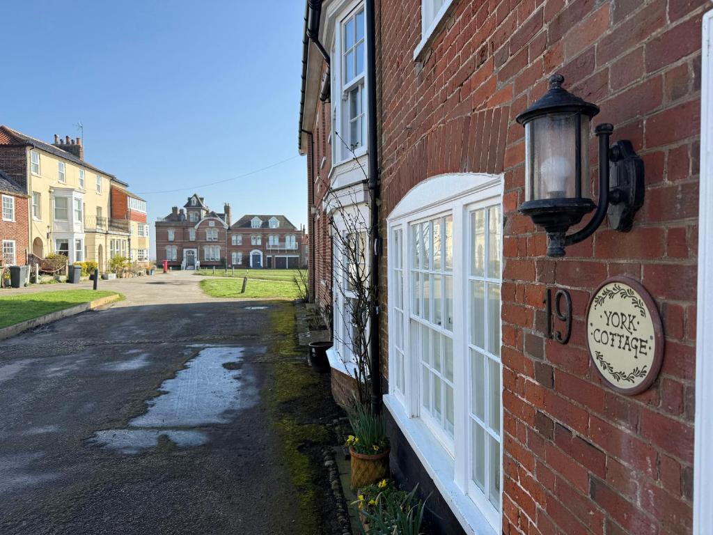 a brick building with a light on the side of it at York Cottage in Southwold