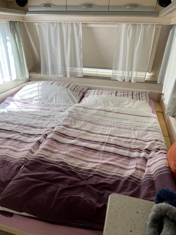 an unmade bed in a room with a window at Kemp Březák- Chlum u Třeboně in Golčŭv Jeníkov