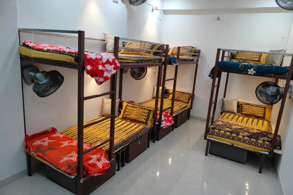 a room with three bunk beds in a room at Agrasen Homestay in Prayagraj