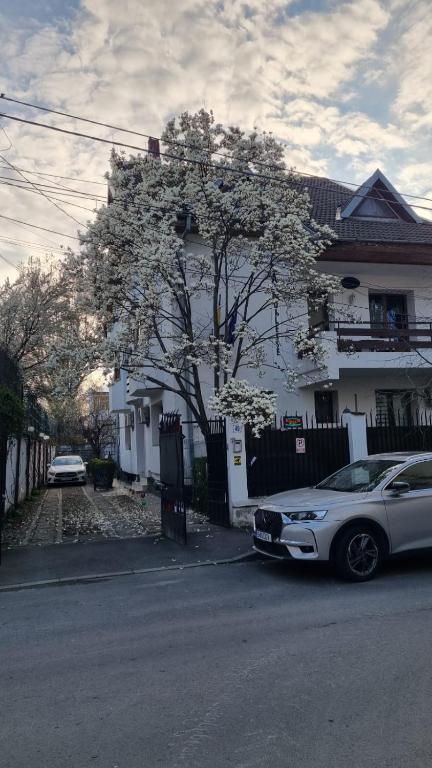 a white car parked in front of a house at Pension La Noblesse in Bucharest