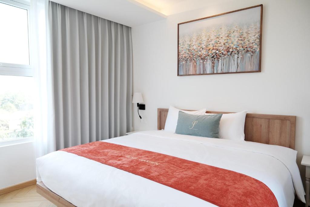 a bedroom with a large white bed and a window at Sadec Garden Boutique Hotel in Ấp Tân Thành (2)