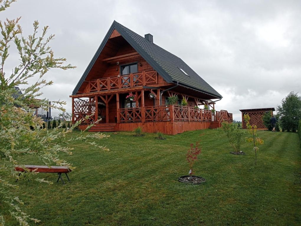 a large wooden cabin with a gambrel roof at Słoneczne Sople in Sople